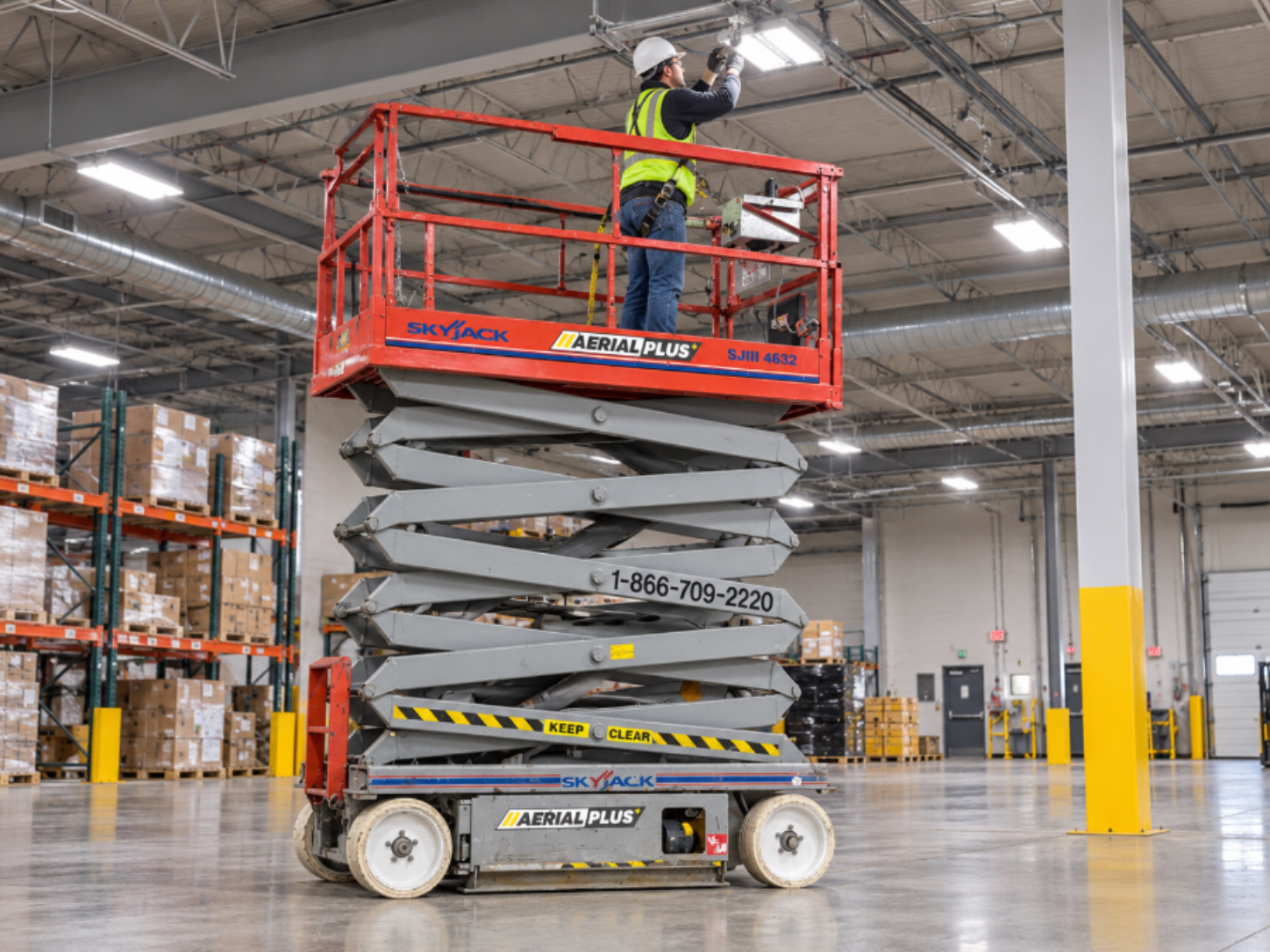 Person on scissor lift in factory setting