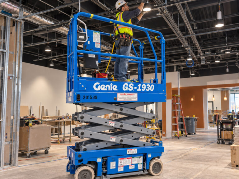 Person working in factory on scissor lift